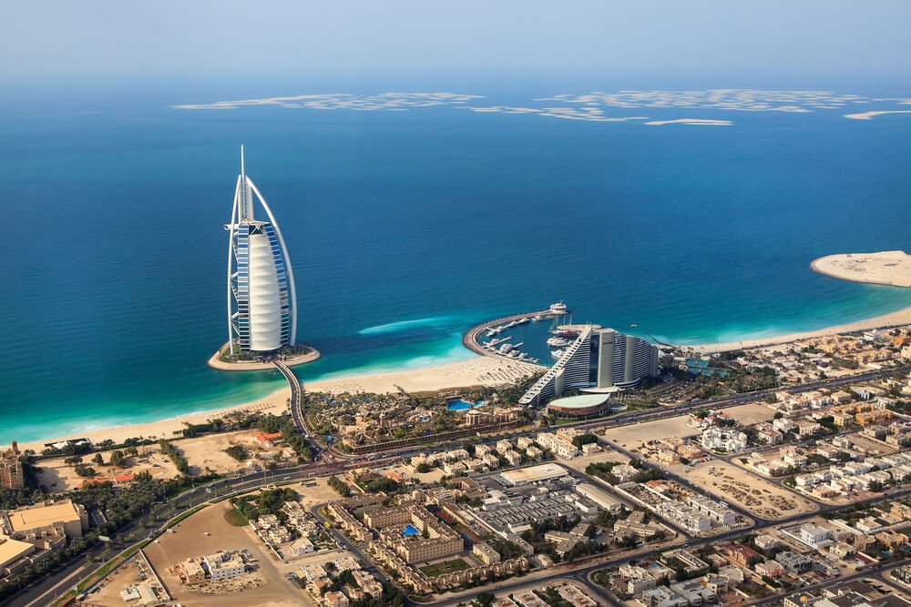The Burj Al Arab, a luxury hotel in Dubai, stands prominently against the skyline of Jumeirah and the Marina.